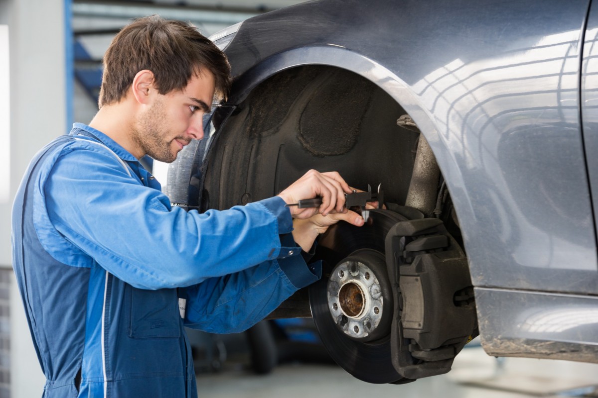 mechanic working on the brakes of a car