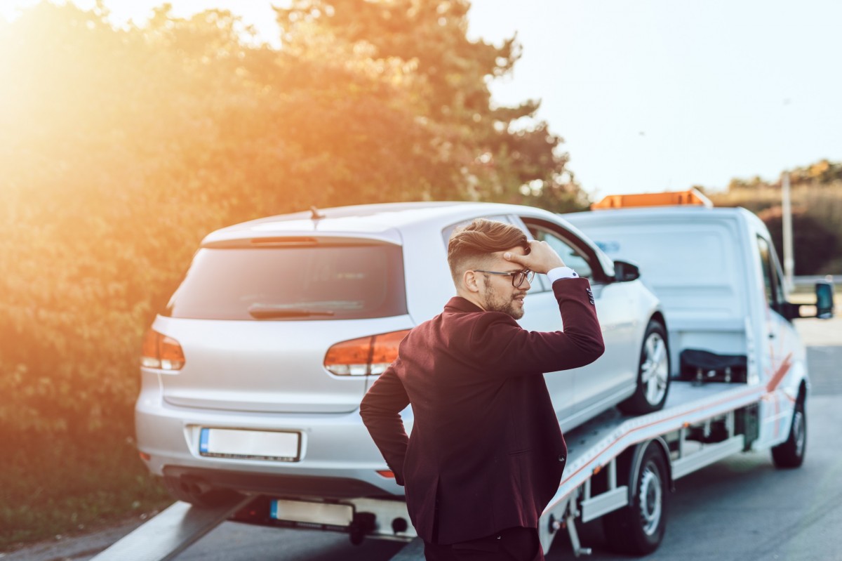 man in front of vehicle being towed