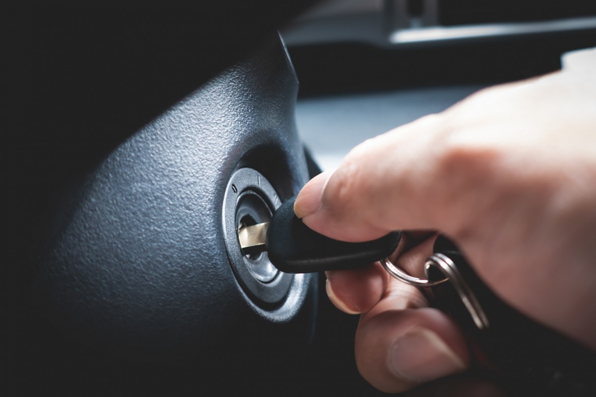 man turning key to car