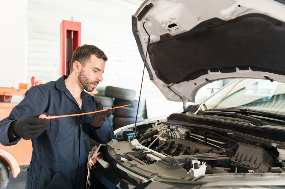 man checking oil stick